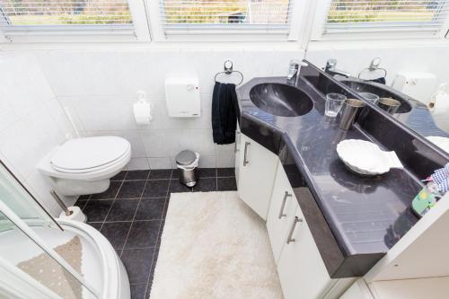 ein Badezimmer mit zwei Waschbecken und einem WC in der Unterkunft Bed & Breakfast Kroese in Oldenzaal