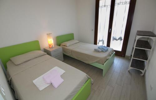 Cette chambre comprend deux lits, une lampe et une échelle. dans l'établissement Appartamento Antonella a due passi dal centro e dal mare, à Grottammare
