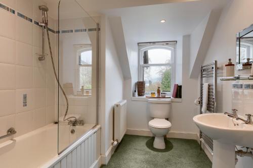 a bathroom with a toilet and a sink and a shower at Ardveich House, large Scottish estate home with loch & hill views in Lochearnhead