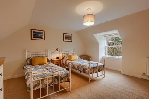 a bedroom with two beds and a window at Ardveich House, large Scottish estate home with loch & hill views in Lochearnhead