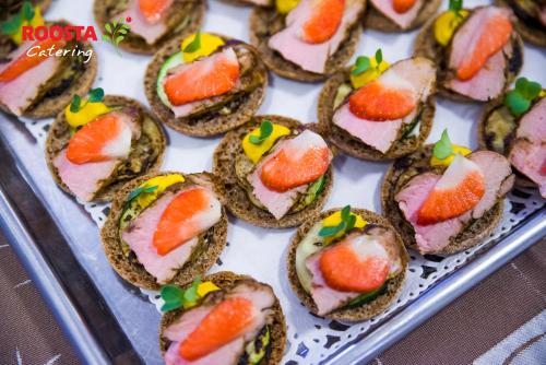 a tray filled with sandwiches with fruit on them at Roosta Holiday Village in Elbiku