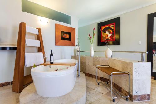 a bathroom with a large tub and a sink at Real de Minas Poliforum in León