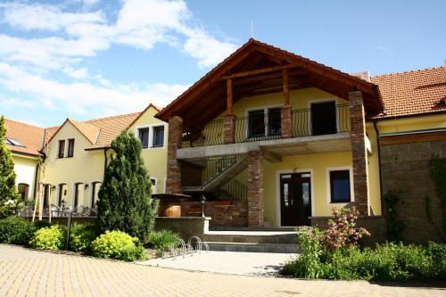 a house with a balcony on the side of it at Penzion Siesta in Valtice