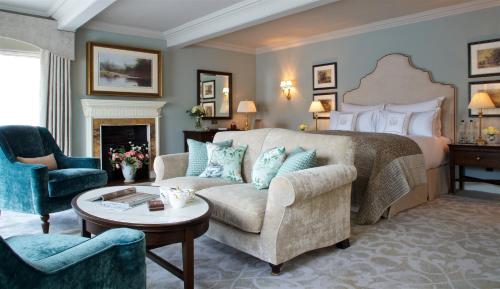 a bedroom with a bed and a couch and a chair at Grantley Hall in Ripon