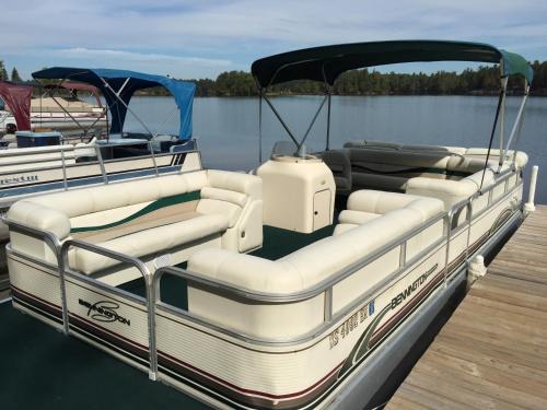 a boat tied up to a dock on the water at Clear Lake Resort in West Branch