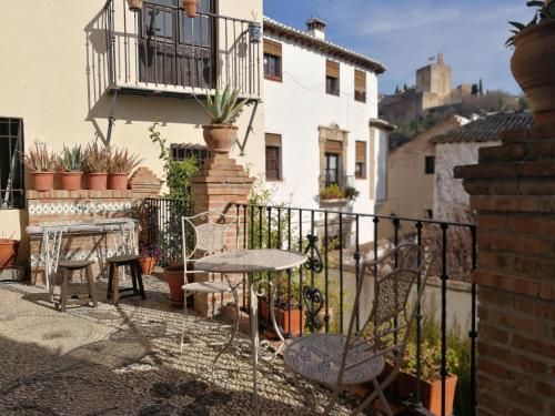 a patio with a table and chairs and a balcony at Casa del Cantaor in Granada