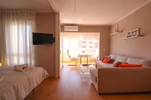 een woonkamer met 2 bedden en een bank en een tafel bij Kumquat apartment in Torrox Costa