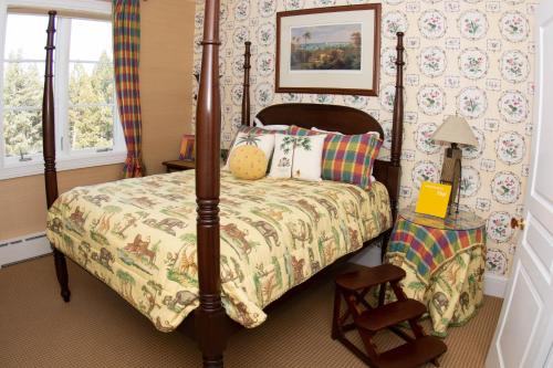 a bedroom with a four poster bed and a chair at The Guest House at Keyah Grande in Pagosa Springs
