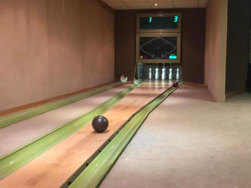 a bowling alley with a ball on the lanes at Hotel Zur Post in Geest