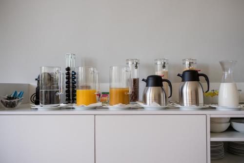 a kitchen counter with several glass jars of orange juice at Decanting Porto House in Porto