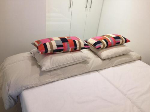 a white bed with two pillows on top of it at Les terrasses de Malmédy in Malmedy