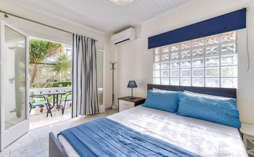 a bedroom with a bed and a large window at Ina Apartment in Kalamaki
