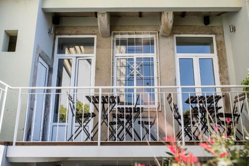 a balcony of a house with tables and chairs at Decanting Porto House in Porto