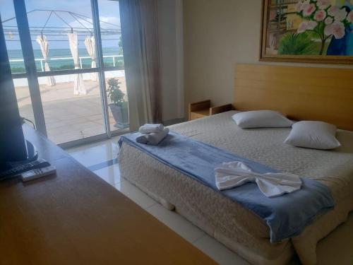a bedroom with a bed with two towels on it at Don Limpone Apart Hotel in Natal
