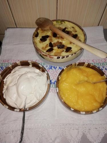 a table topped with three bowls of food on a table at Pensiunea Mara in Deseşti