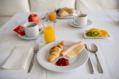 a table with a plate of breakfast foods and orange juice at Decanting Porto House in Porto