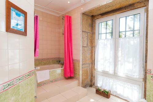 a bathroom with a tub and a window at Hospedaria do Convento d'Aguiar- Turismo de Habitacao in Figueira de Castelo Rodrigo