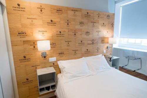 a bedroom with a bed with a wooden wall at Decanting Porto House in Porto