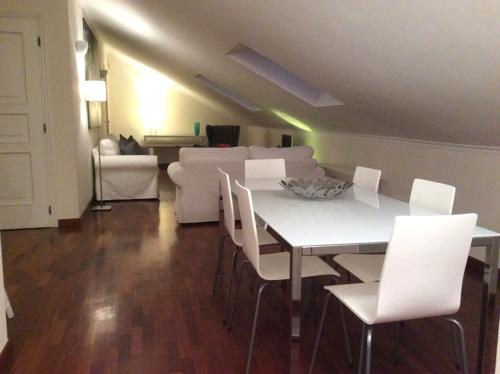 a living room with a white table and white chairs at Apartment La Mansarda in Alba
