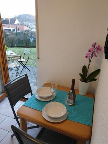 a table with plates and glasses and a bottle of wine at Wohlfühl-Apartment Bad Kissingen I in Bad Kissingen