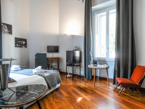 una camera d'albergo con letto, TV e finestra di Mecenate Rooms a Roma