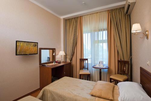 a hotel room with a bed and a window at Yug Hotel in Krasnodar