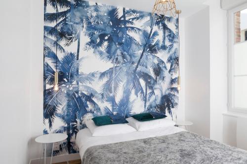 a bedroom with a blue mural of palm trees at Résidence Solférino in Laval