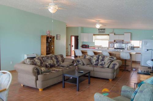 sala de estar con 2 sofás y cocina en Casa Pelicano, en Puerto Peñasco