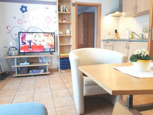 a living room with a table and a television at Feriendomizil am Hafen in Zingst