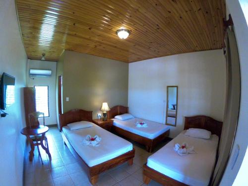 Habitación con 2 camas y mesa. en Hotel Los Higuerones, en Canoas