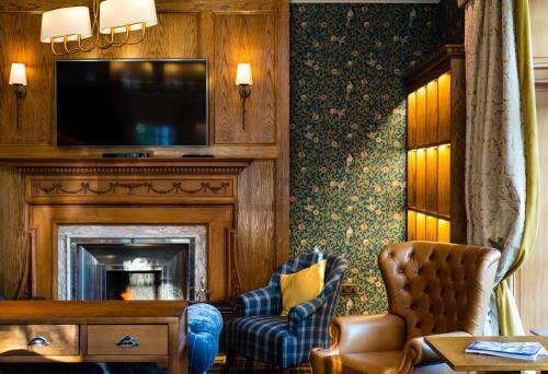 a living room with a fireplace and a tv at Murrayshall Country Estate in Perth