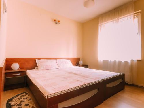 a bedroom with a large bed with a large window at Spacious Apartment near Peles in Sinaia