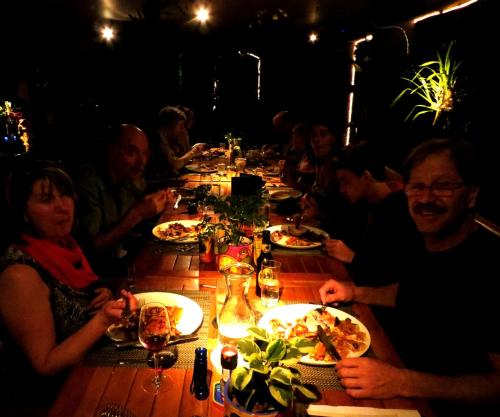 a group of people sitting at a long table eating food at Pura Vida Hotel in Alajuela City