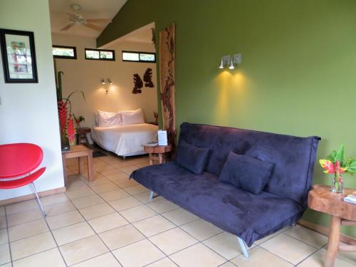 a living room with a couch and a bed at Pura Vida Hotel in Alajuela City