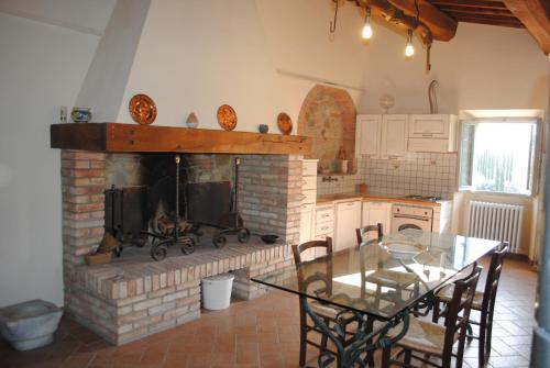 a kitchen with a brick fireplace and a glass table at Agriturismo Fattoria di Malavolta in Florence