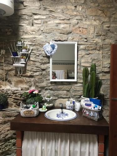 a bathroom with a sink and a stone wall at Casa de Chanca in Penela