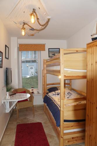 a bedroom with a bunk bed and a desk at Ferienwohnung Baltic Sea in Börgerende-Rethwisch