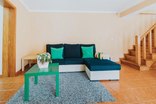 a living room with a blue couch and a table at 10 min from the beach Game room with fireplace Pool in Seixo