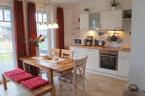 a kitchen with a wooden table with chairs and a dining room at Ferienwohnung Baltic Sea in Börgerende-Rethwisch