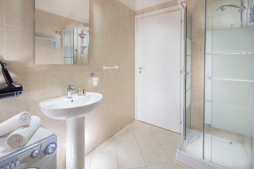 La salle de bains est pourvue d'un lavabo et d'une douche. dans l'établissement Studioflat University, in centro a Bologna, à Bologne