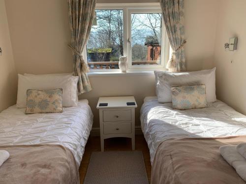 two twin beds in a room with a window at Owls House, White Cross Bay, Ambleside, Windermere in High Wray