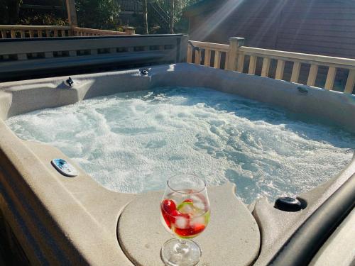 a glass of wine in a jacuzzi tub at Owls House - Lodge with hot tub- Lake District in Windermere
