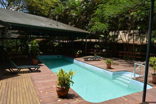 a swimming pool with two chairs and a table at Rainforest Eco Lodge in Suva