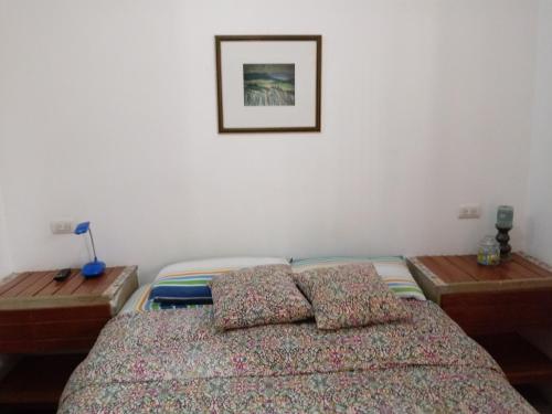a bedroom with a bed and two wooden tables at Los Pinos de Zorritos Condominio in Zorritos