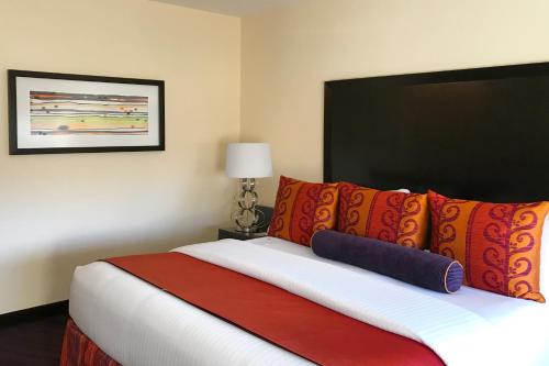 a bedroom with a bed with orange and red pillows at Washington Plaza Hotel in Washington