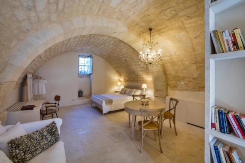 多娜芙佳塔的住宿－Terre di Cavalusi Relais，一间卧室和一间带一张床铺和一张桌子的客厅