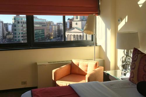 a bedroom with a chair and a window and a bed at Washington Plaza Hotel in Washington