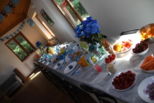 a table with plates of food and bowls of fruit at Dom imprezowy z noclegami Dziecinów in Dziecinów
