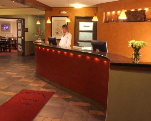 a woman standing at a bar in a restaurant at Best Western Snowcap Lodge in Cle Elum
