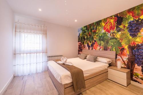 a bedroom with a large painting on the wall at La Casita de Albelda in Albelda de Iregua